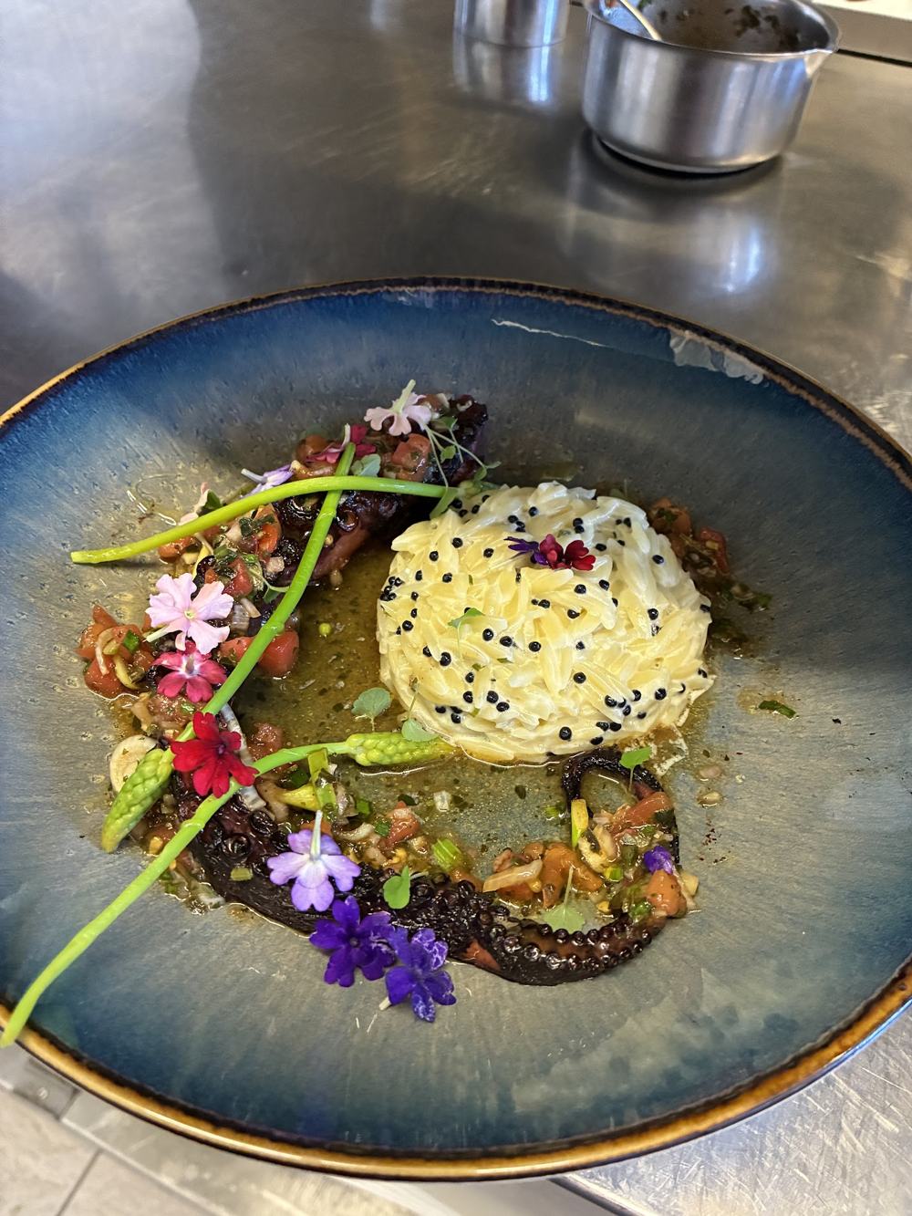 Poulpe grillé sur orzo crémeux, fleurs comestibles